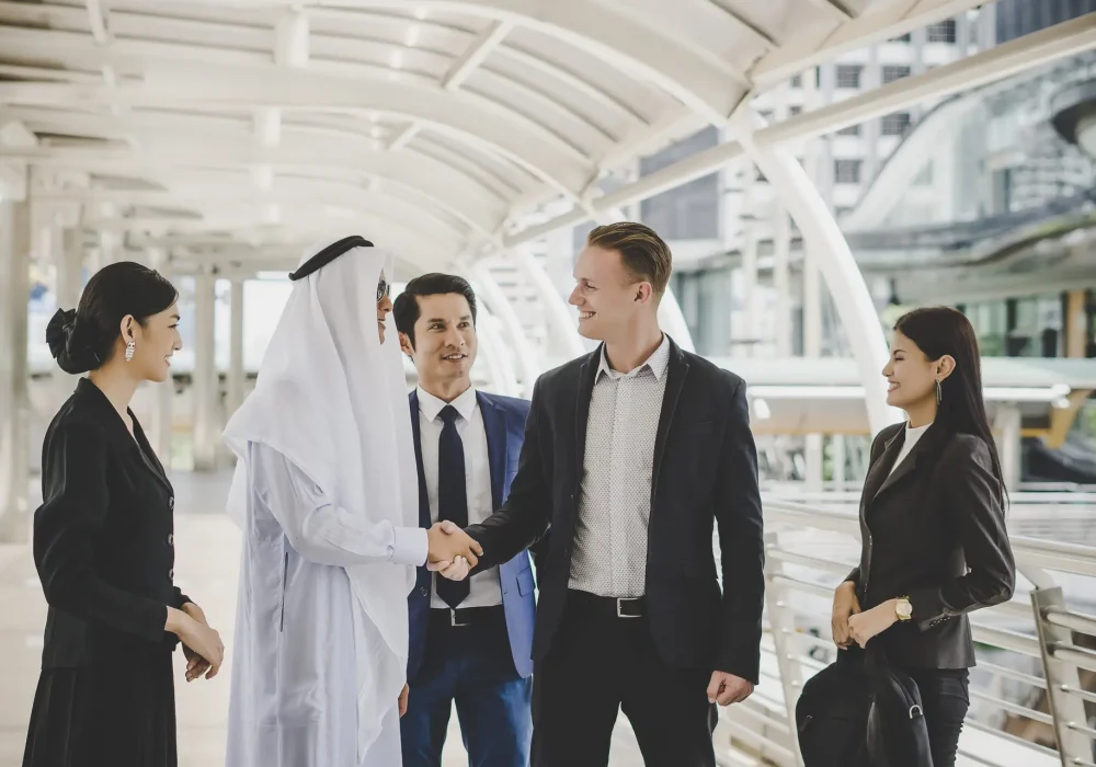 Portrait of business partners greeting one another by handshaking on the way to office.